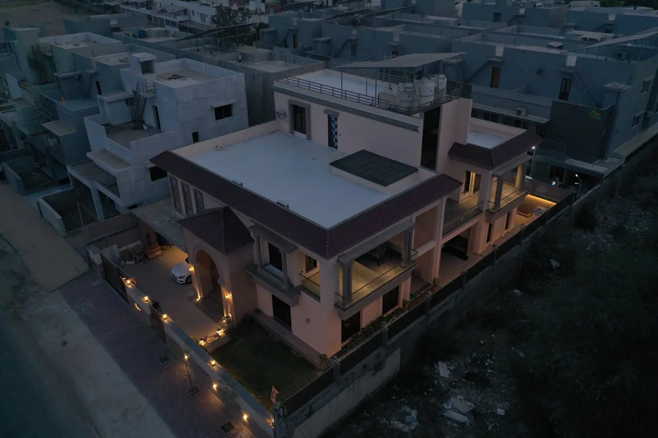 Aerial view of PS Bungalow at dusk with its garden and façade lighting