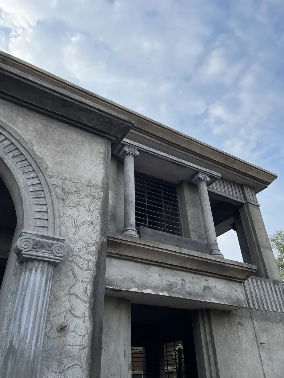 Arched façade with columns and cornices at PS Bungalow during finishing